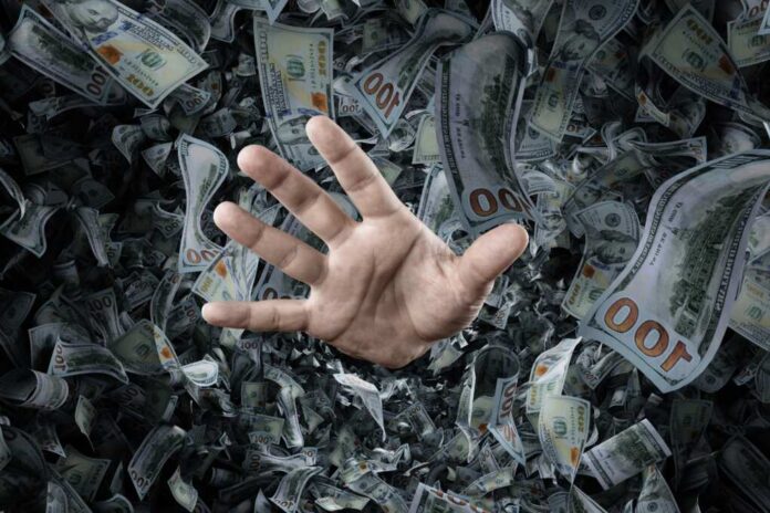 A,Businessman's,Hand,Is,Sticking,Out,Of,A,Pile,Of