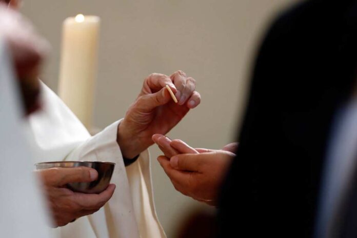 Sunday,Mass,In,A,Catholic,Parish.,Priest,Giving,Holy,Communion.