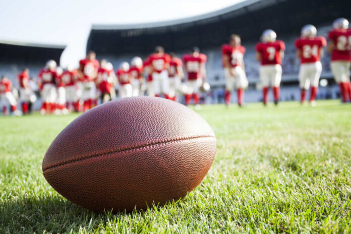 Close,Up,Of,An,American,Football,On,The,Field,,Players
