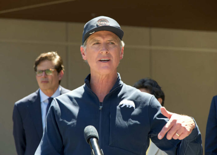A man speaking at a press conference outdoors with a microphone