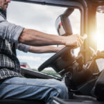 Massive Rig Danger Ends—New Safety Rules! A truck driver gripping the steering wheel inside a vehicle cabin