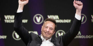 Person in business attire raising arms in celebration at a technology conference