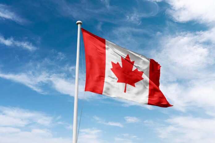 shutterstock_2496996631.jpg Canadian flag waving against a blue sky