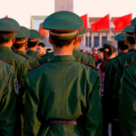 Soldiers in green uniforms standing in formation during a public event