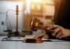 A gavel being struck on a desk in a courtroom setting