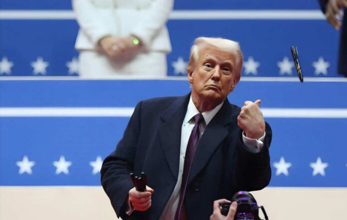 A man in formal attire gesturing during a political event
