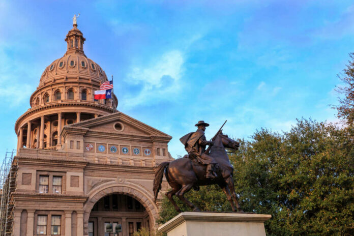 shutterstock388837831jpg Statue of a rider in front of the Texas State Capitol building under a blue sky