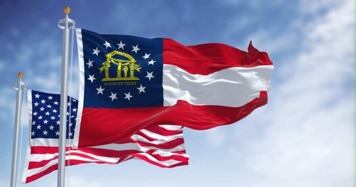 Georgia state flag and American flag waving against a blue sky