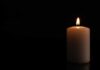 A lit candle against a black background