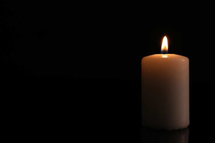 A lit candle against a black background