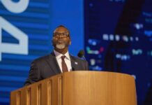 A business leader speaking at a podium during a conference