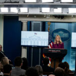Pentagon’s Media Eviction Sparks Outrage A woman speaking at a podium during a White House press briefing with journalists in attendance