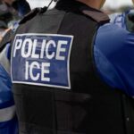 Close-up of a police officer's vest with 'POLICE ICE' label