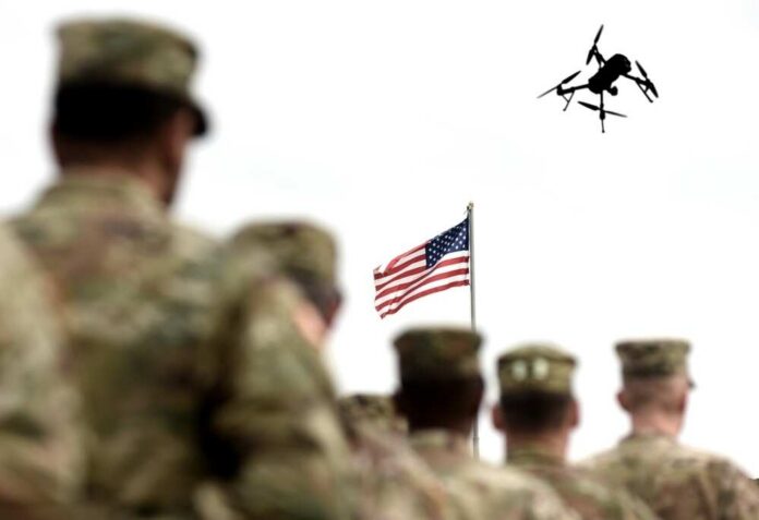 shutterstock_2690863839.jpg Military personnel standing in formation with a drone flying overhead and an American flag in the background