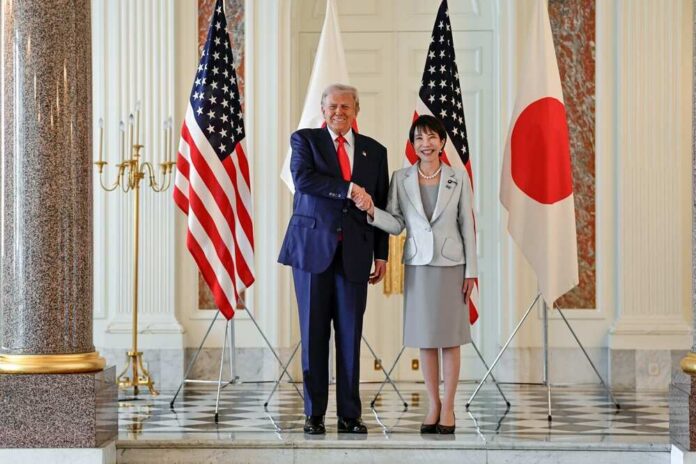 Two political leaders shaking hands in front of flags