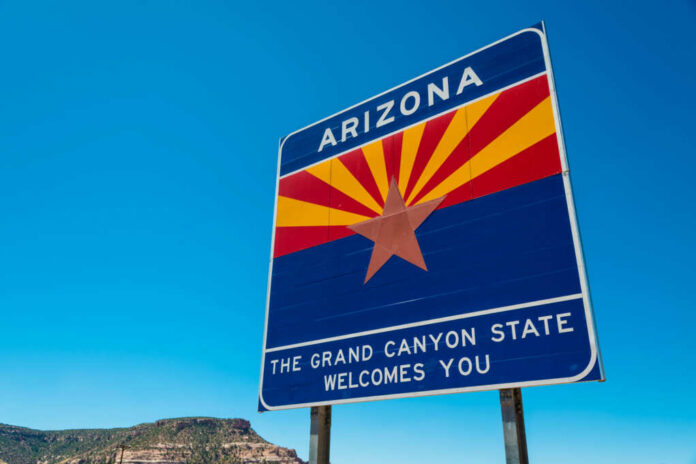 Welcome sign for Arizona with a blue sky background