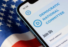 Mobile phone displaying the Democratic National Committee website on an American flag background