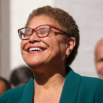 A smiling woman in a green blazer at an outdoor event