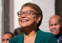 A smiling woman in a green blazer at an outdoor event