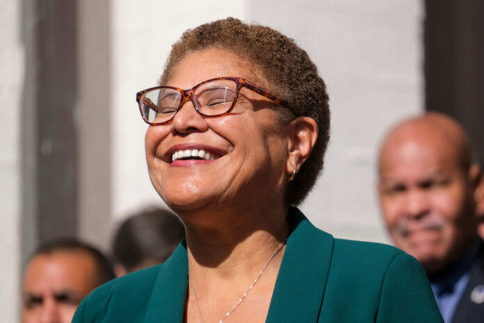 A smiling woman in a green blazer at an outdoor event