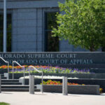 Exterior view of the Colorado Supreme Court building with landscaped flowers
