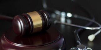 A gavel and a stethoscope on a dark surface