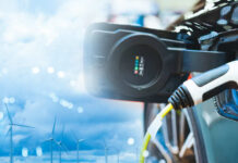 Electric vehicle charging with wind turbines in the background