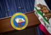 Podium with the seal of the Governor of California and state flag in the background