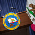 Podium with the seal of the Governor of California and state flag in the background