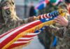 Soldiers holding a ceremonial American flag during a military event