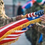 Soldiers holding a ceremonial American flag during a military event