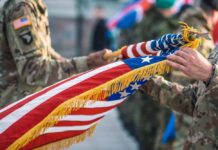 Soldiers holding a ceremonial American flag during a military event