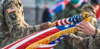 Soldiers holding a ceremonial American flag during a military event