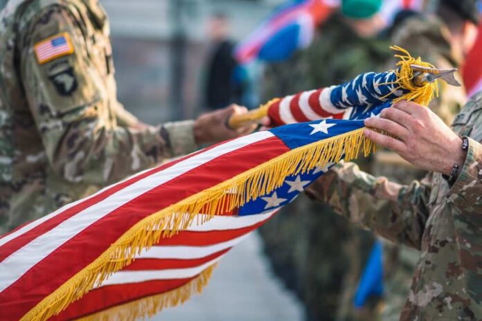 Soldiers holding a ceremonial American flag during a military event
