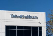 Signage of UnitedHealthcare on a modern building against a clear blue sky