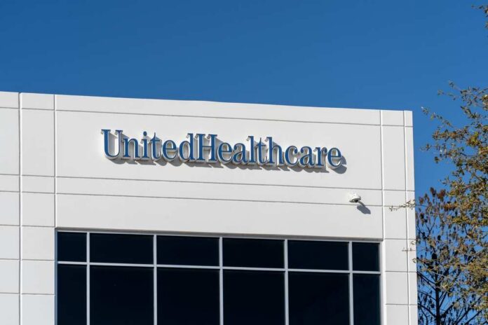 Signage of UnitedHealthcare on a modern building against a clear blue sky