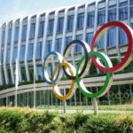 Colorful Olympic rings displayed in front of a modern building