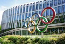 Colorful Olympic rings displayed in front of a modern building
