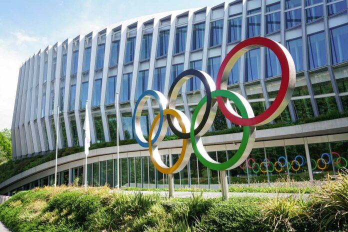 shutterstock_2163962535.jpg Colorful Olympic rings displayed in front of a modern building