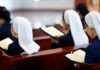 Nuns seated in a church reading from books