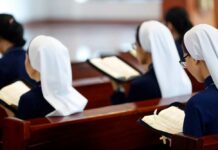 Nuns seated in a church reading from books
