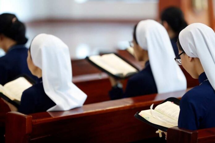 Nuns seated in a church reading from books