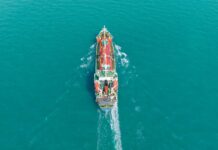 Aerial view of a cargo ship navigating through turquoise waters