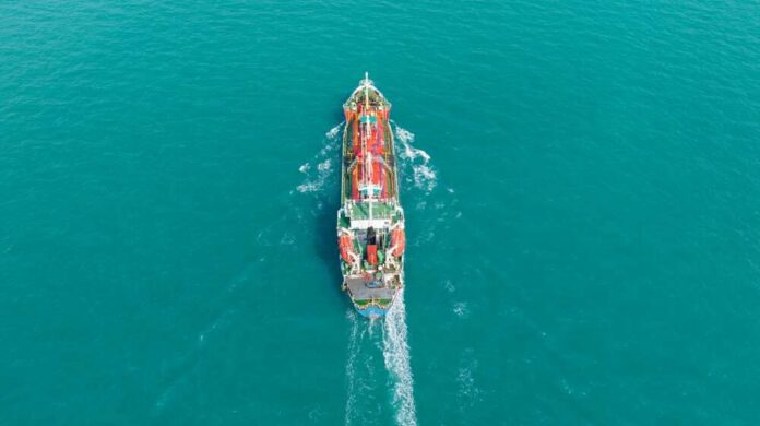 Aerial view of a cargo ship navigating through turquoise waters