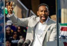 A speaker passionately addressing a crowd at an outdoor event