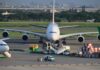 Large airplane at an airport with ground service vehicles