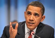 A man speaking passionately at a conference with a microphone in front of him