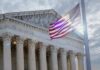 The Supreme Court building with an American flag waving in front