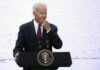 A man in a suit speaking at a podium with a presidential seal