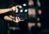 Hands holding a film clapperboard ready for a scene take